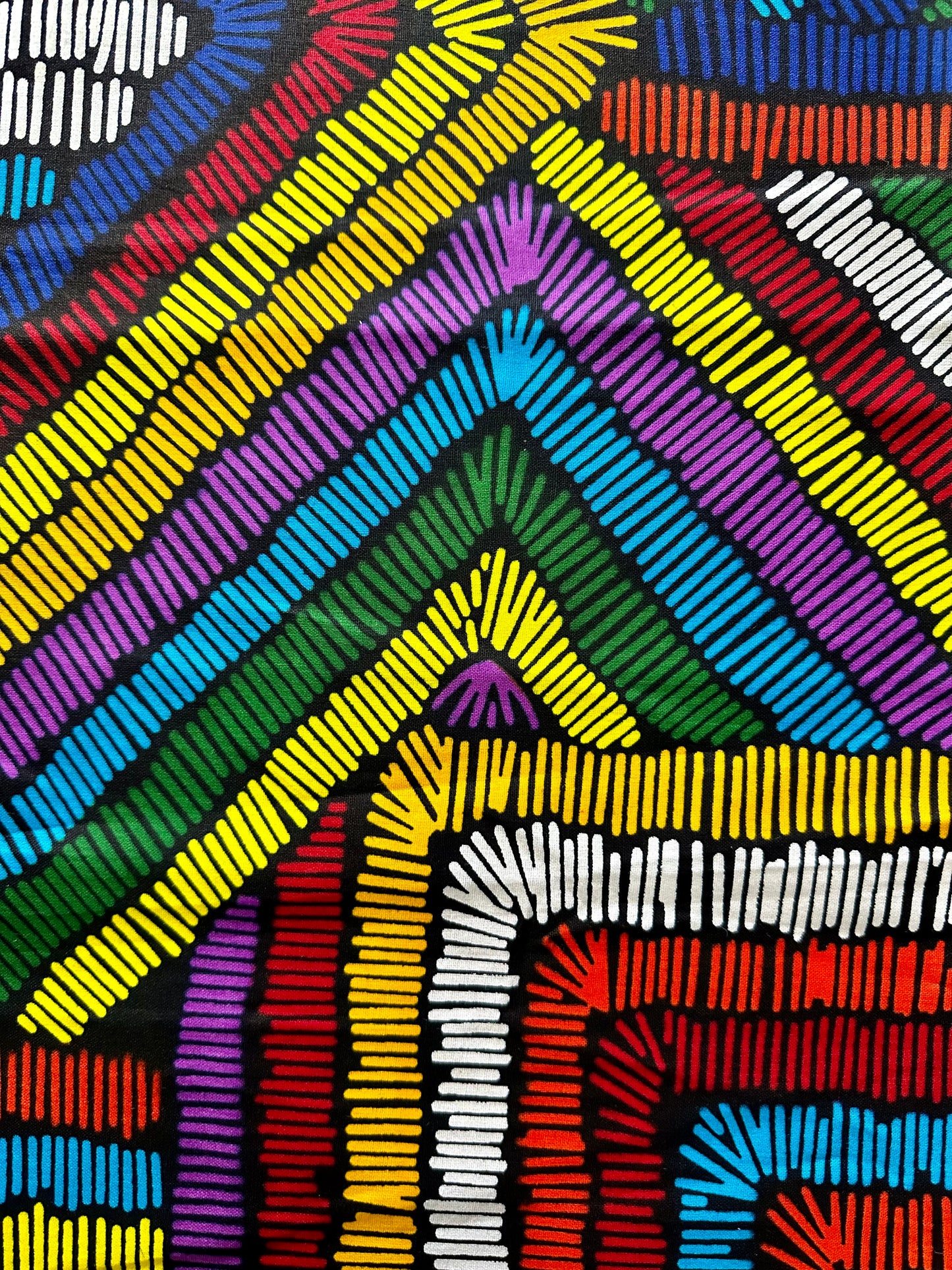 The colorfully wire headwrap features vibrant hues of red, blue, green, and yellow, creating a stunning rainbow effect.