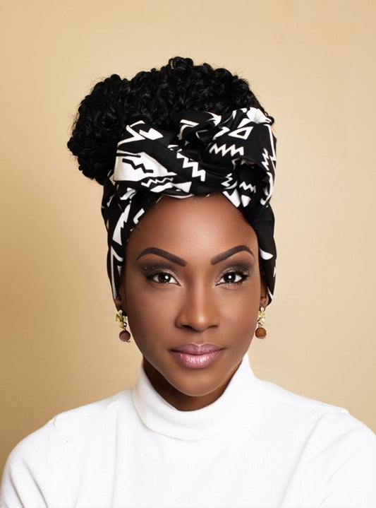 Woman wearing a black and white patterned headscarf against a beige background