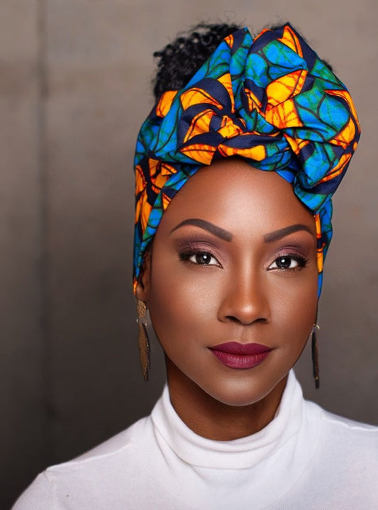 Woman wearing a colorful headscarf with a neutral background
