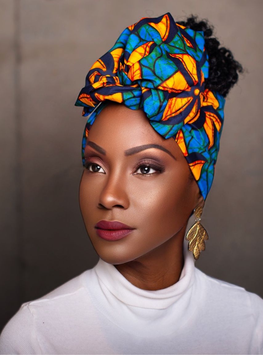Stylish African print Zalika wire headwrap in blue and orange tones, worn by a woman with natural textured hair and gold earrings.