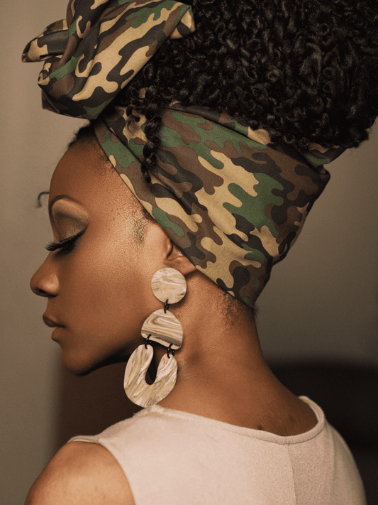 The Camouflage wire headwrap typically features natural earth colors that are designed to blend in with the surrounding environment. These colors are often inspired by the colors found in nature, such as greens, browns, and earthy tones.
